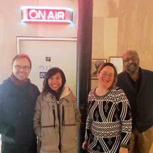 Ari and Peter Krzyzek with hosts beside an ON AIR sign before a radio appearance