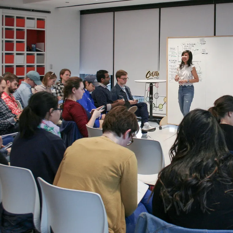 Ari Krzyzek presenting to a seated audience at a speaking engagement